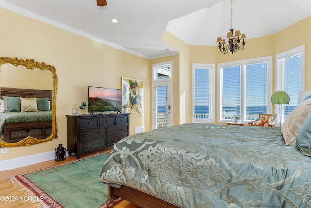 bedroom with crown molding, hardwood / wood-style floors, multiple windows, and an inviting chandelier