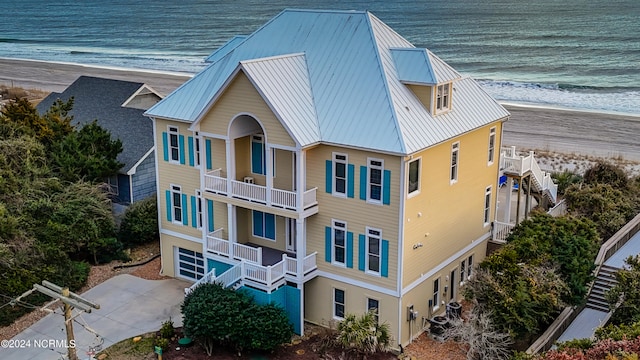 view of front of property with a balcony and a water view