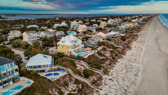 birds eye view of property with a water view and a beach view