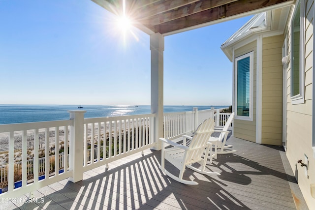 wooden terrace with a water view and a beach view