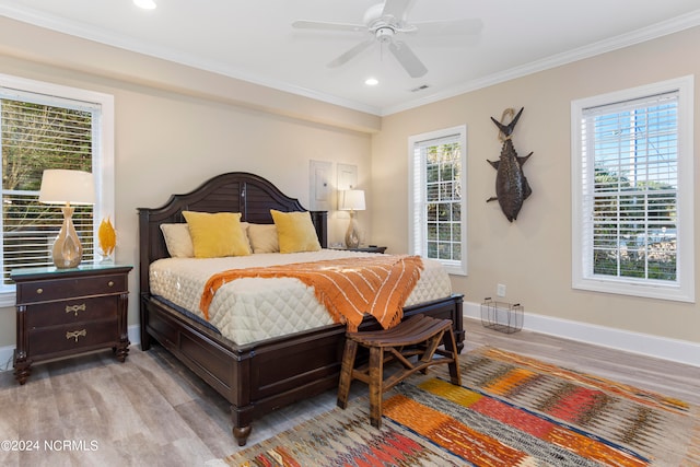 bedroom featuring ceiling fan, multiple windows, light wood-type flooring, and crown molding