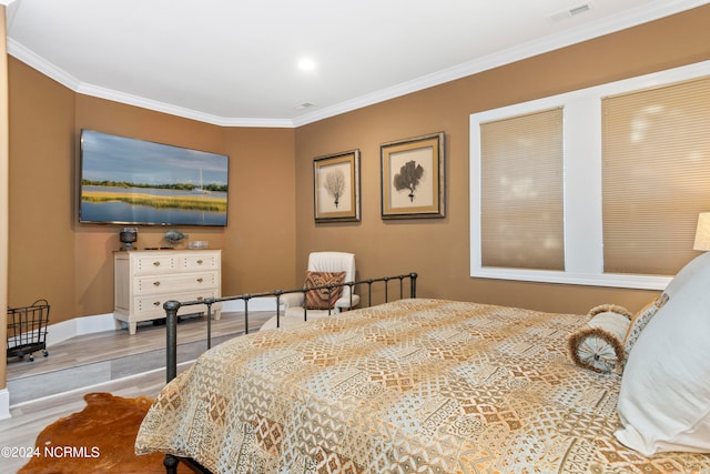 bedroom featuring ornamental molding and light wood-type flooring