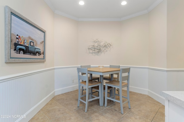 tiled dining area featuring crown molding