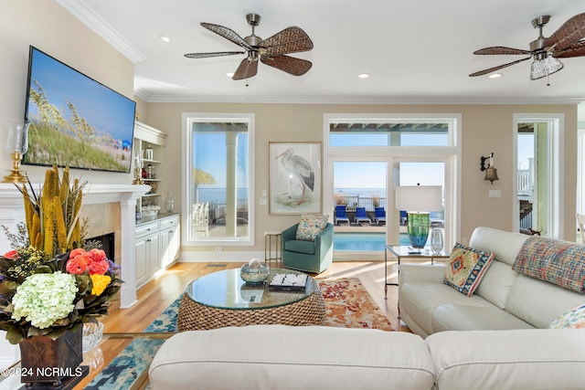 living room with light hardwood / wood-style flooring, ceiling fan, and a wealth of natural light