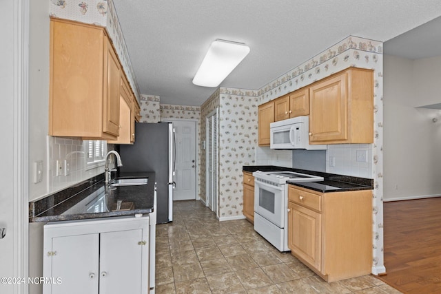 kitchen featuring light wood-type flooring, white appliances, a textured ceiling, light brown cabinets, and sink