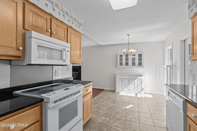 kitchen featuring white appliances, light tile floors, tasteful backsplash, a textured ceiling, and a notable chandelier