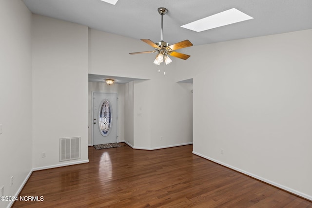 spare room with dark hardwood / wood-style flooring, ceiling fan, and lofted ceiling with skylight