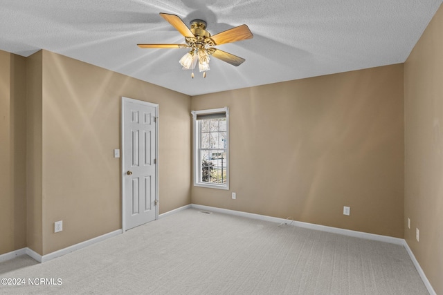 carpeted spare room with ceiling fan and a textured ceiling