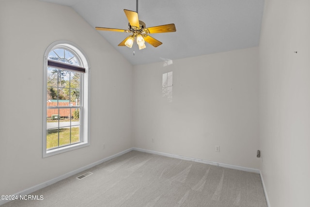 empty room with light colored carpet, ceiling fan, and lofted ceiling