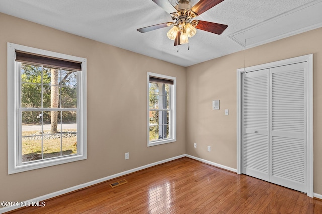 unfurnished bedroom featuring multiple windows and light wood-type flooring