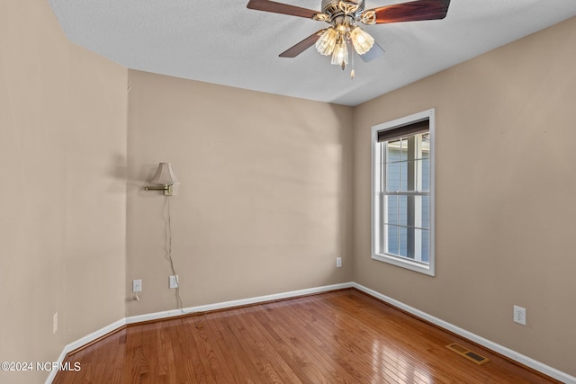 spare room with ceiling fan, a textured ceiling, and hardwood / wood-style floors