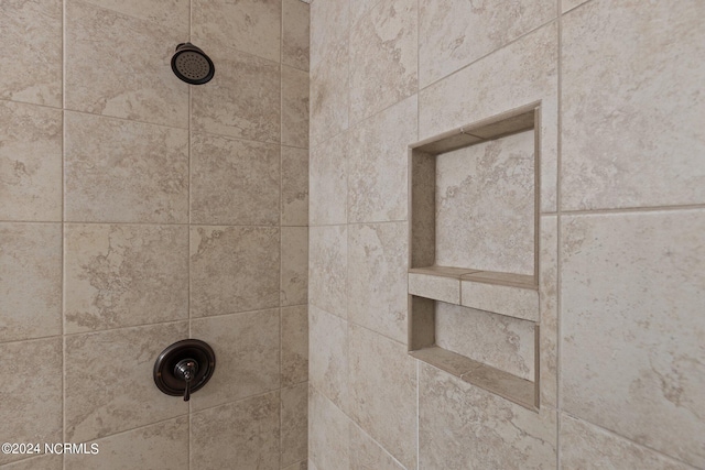 interior details with a tile shower