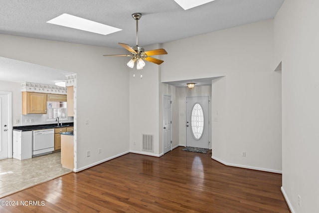 entrance foyer featuring a skylight, a healthy amount of sunlight, and light hardwood / wood-style flooring