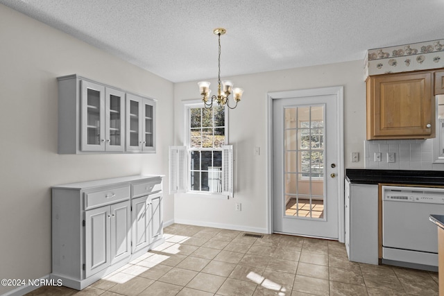 interior space with a chandelier, light tile flooring, and a textured ceiling