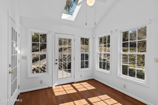 unfurnished sunroom with ceiling fan and vaulted ceiling with skylight