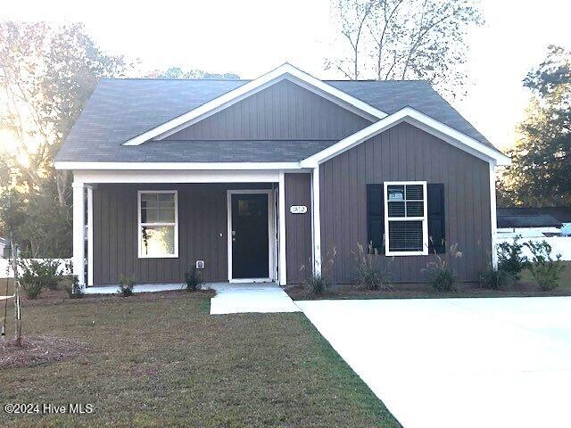 view of front of home featuring covered porch and a front yard