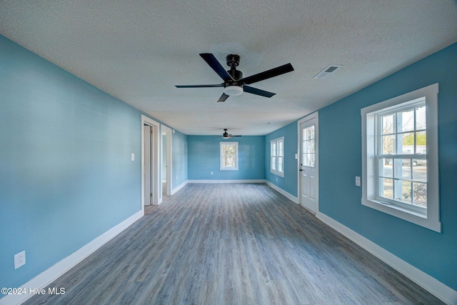 unfurnished living room featuring ceiling fan, wood-type flooring, and a textured ceiling