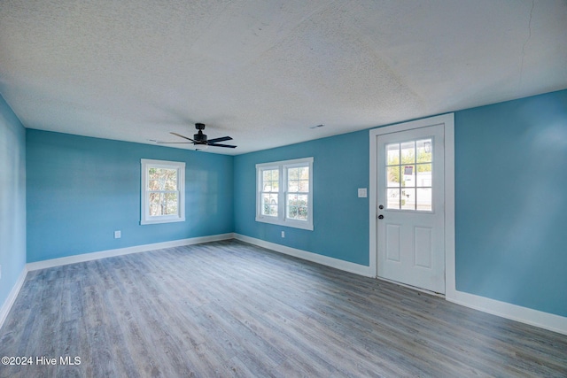 entrance foyer featuring a wealth of natural light, hardwood / wood-style floors, ceiling fan, and a textured ceiling