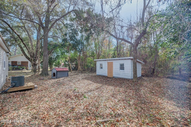 view of yard with central AC unit and a storage shed