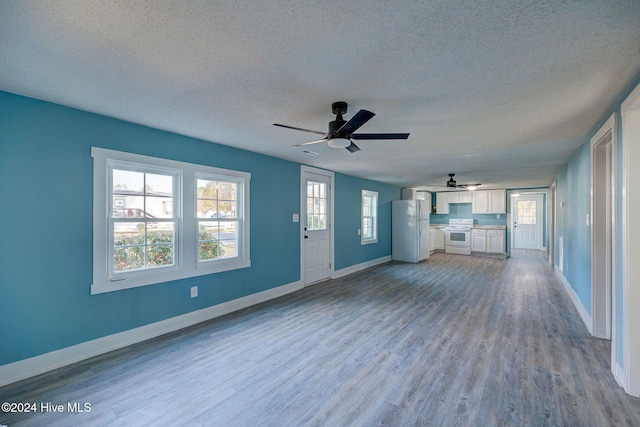 unfurnished living room with ceiling fan, light hardwood / wood-style flooring, and a textured ceiling