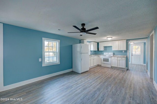 kitchen featuring plenty of natural light, white cabinets, white appliances, and light hardwood / wood-style flooring