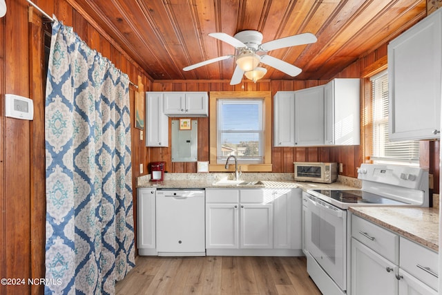 kitchen with light wood-type flooring, wooden walls, ceiling fan, white appliances, and a wealth of natural light