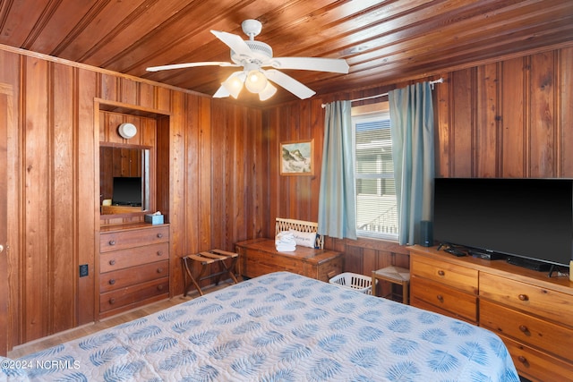 bedroom with ceiling fan, wood ceiling, and wooden walls