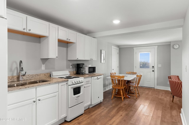 kitchen featuring white appliances, sink, light hardwood / wood-style floors, and white cabinetry