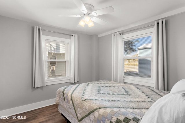 bedroom with dark hardwood / wood-style flooring and ceiling fan