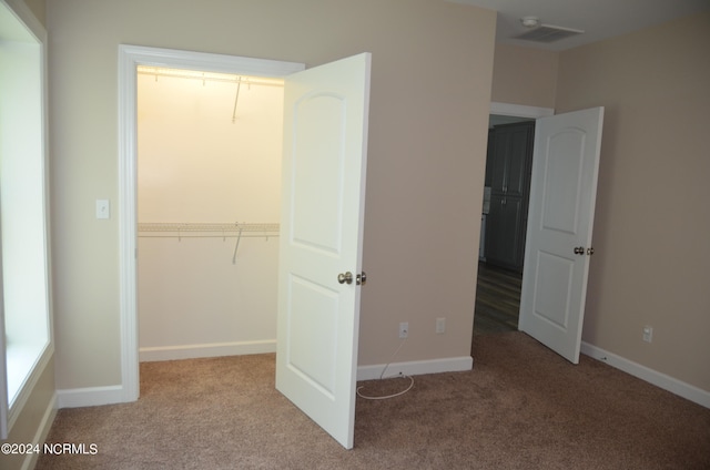 unfurnished bedroom with carpet flooring and a closet