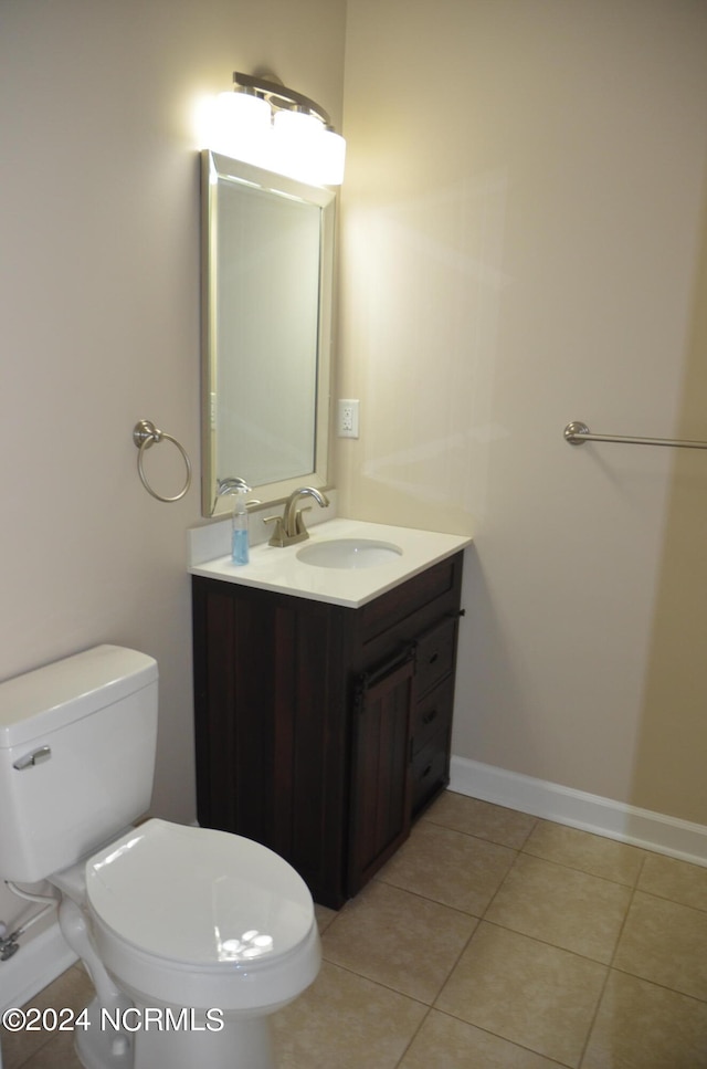 bathroom featuring tile flooring, vanity, and toilet