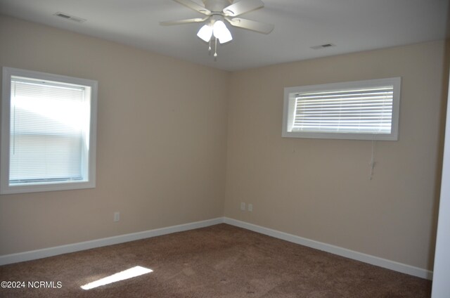 carpeted spare room with plenty of natural light and ceiling fan