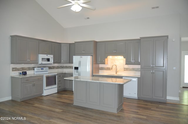 kitchen with high vaulted ceiling, white appliances, dark hardwood / wood-style floors, and tasteful backsplash