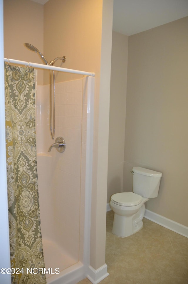 bathroom featuring a shower, tile flooring, and toilet