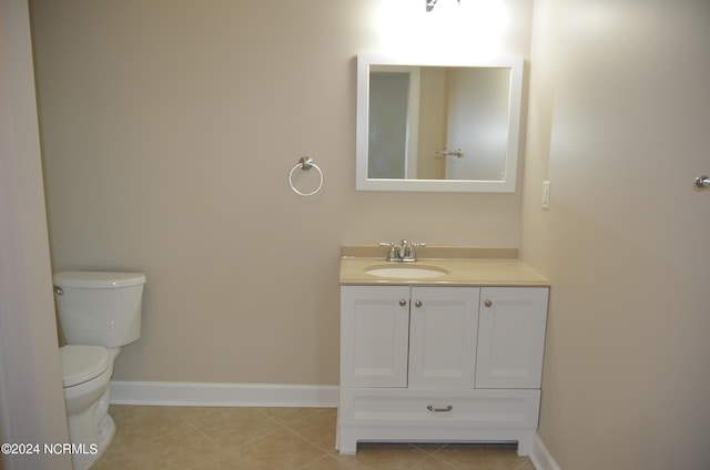 bathroom featuring tile floors, vanity, and toilet