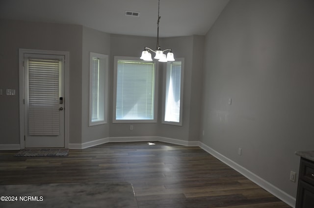 unfurnished dining area with dark hardwood / wood-style flooring and an inviting chandelier