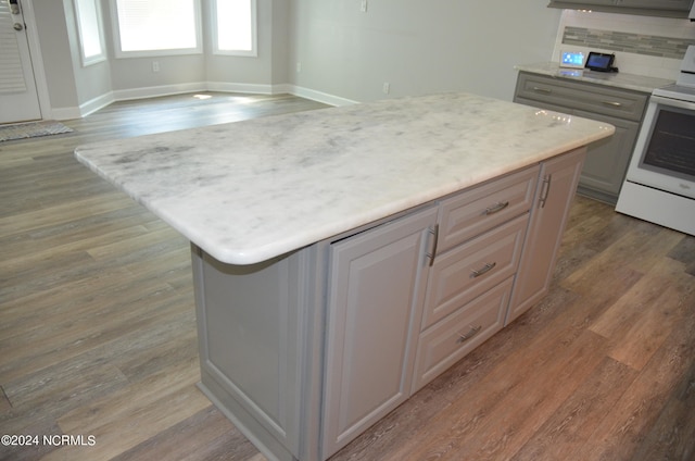 kitchen with hardwood / wood-style flooring, tasteful backsplash, and a kitchen island