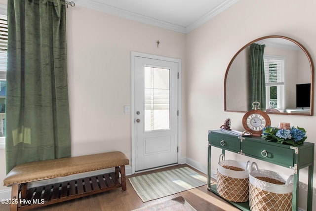 doorway to outside with baseboards, ornamental molding, and wood finished floors