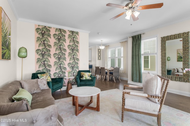 living room featuring baseboards, ceiling fan, ornamental molding, and wood finished floors