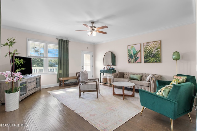 living room with baseboards, ornamental molding, a ceiling fan, and wood finished floors
