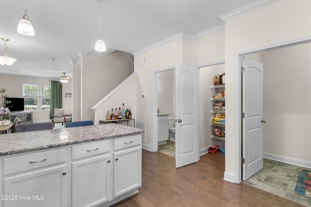 kitchen with a ceiling fan, dark wood-style flooring, white cabinetry, and decorative light fixtures