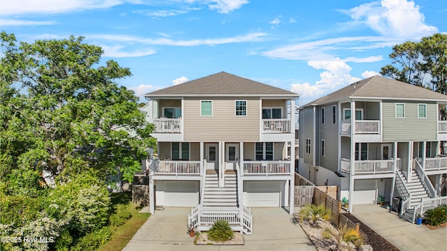 coastal home featuring stairway, driveway, and a garage