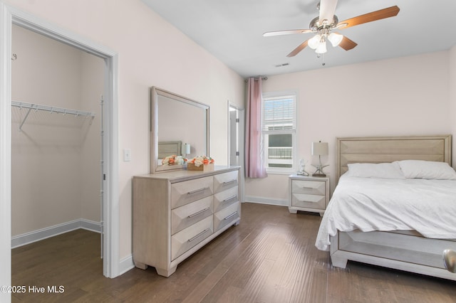 bedroom featuring baseboards, visible vents, dark wood-style floors, and a spacious closet