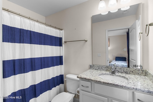 ensuite bathroom with connected bathroom, toilet, and vanity