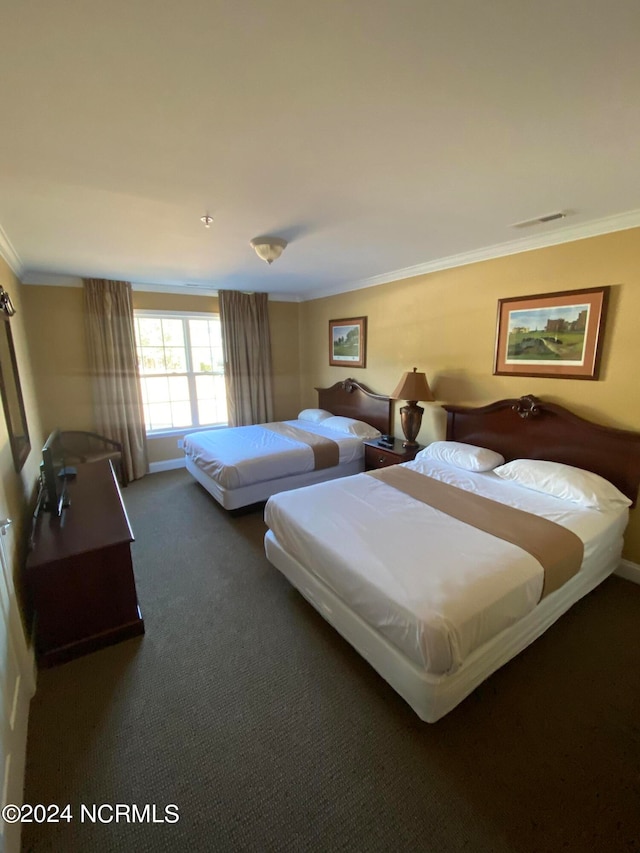 bedroom featuring crown molding and dark carpet