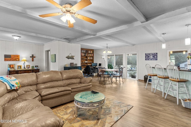 living room with light wood-type flooring, beamed ceiling, ceiling fan, a textured ceiling, and french doors