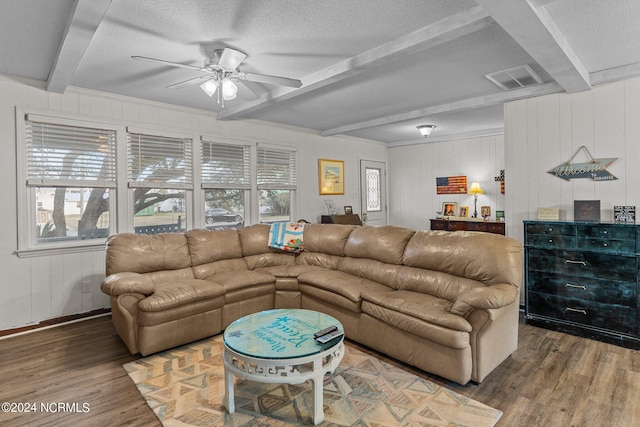 living room featuring beamed ceiling, a healthy amount of sunlight, ceiling fan, and dark hardwood / wood-style flooring