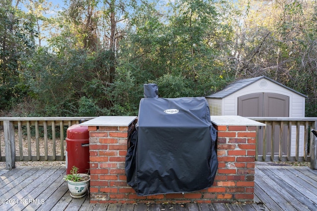 wooden deck featuring a grill and a shed