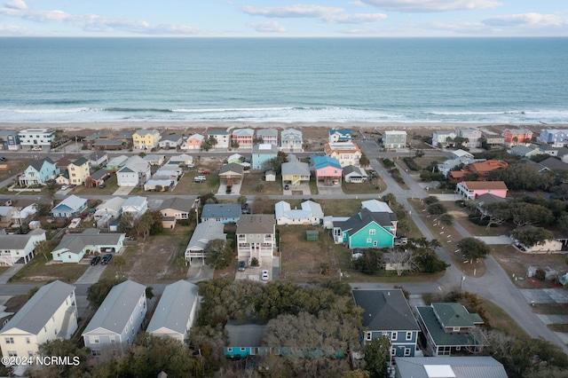 birds eye view of property with a water view and a beach view