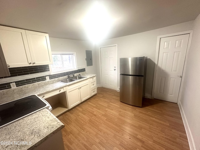 kitchen featuring tasteful backsplash, stainless steel fridge, light hardwood / wood-style floors, sink, and white cabinets